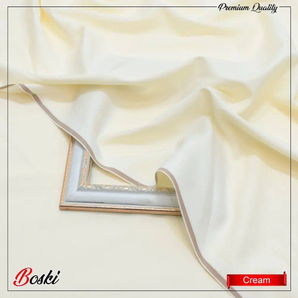 Cream-colored silky fabric draped over an ornate silver picture frame on a matching cream background